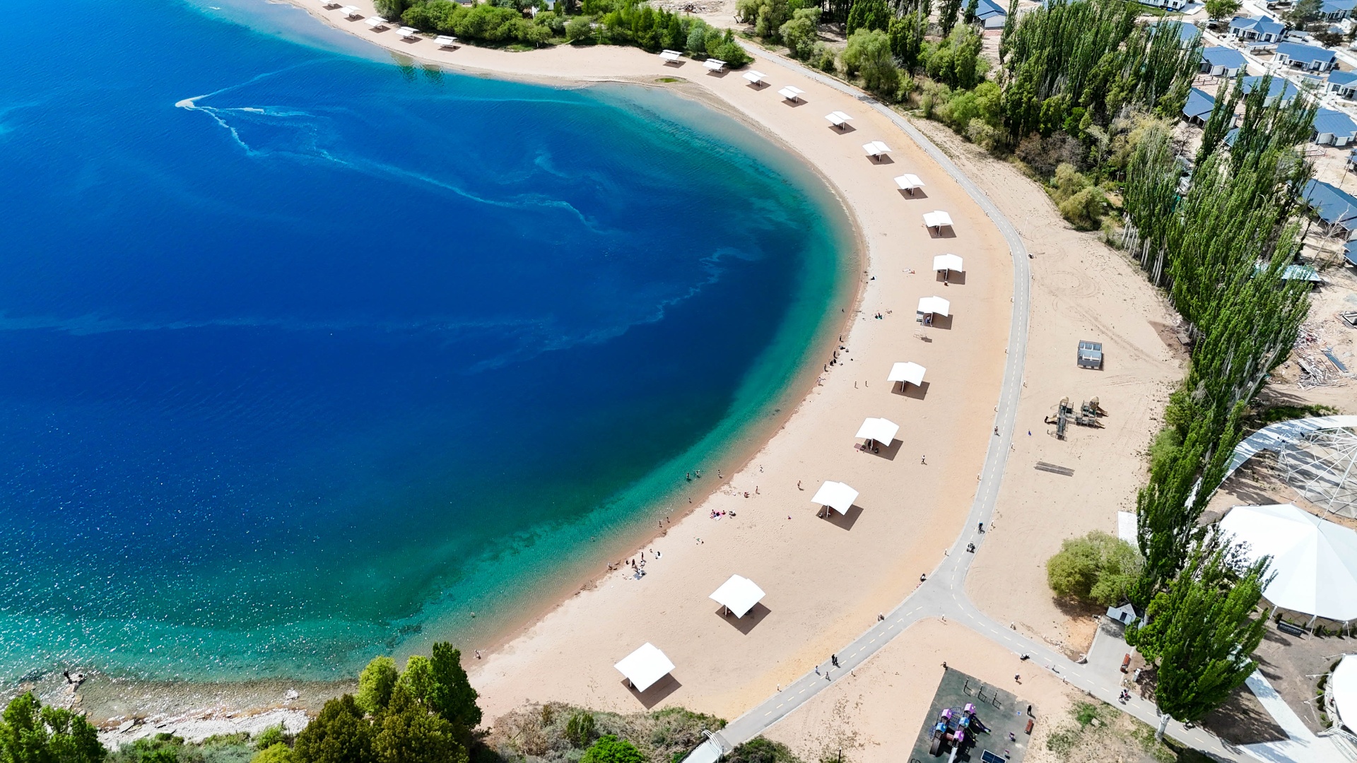 Пляж с белыми навесами на берегу Иссык-Куля